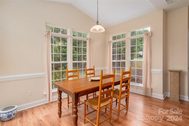 dining area with light hardwood / wood-style floors and vaulted ceiling