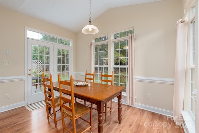 dining room with light hardwood / wood-style floors and vaulted ceiling