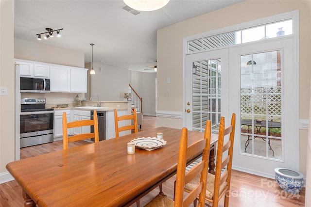 dining area with ceiling fan, light hardwood / wood-style floors, and sink