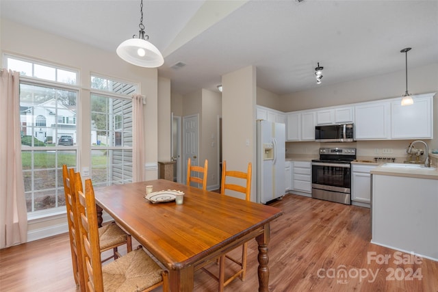 dining space with light wood-type flooring and sink