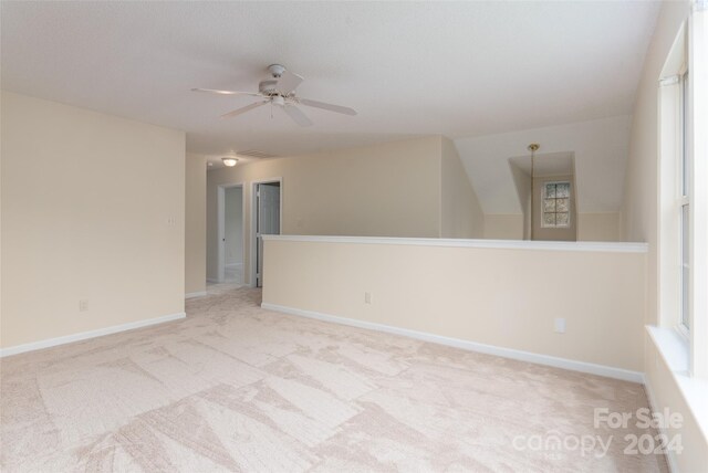 empty room featuring ceiling fan and light carpet