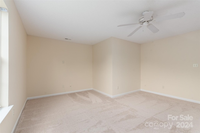 unfurnished room featuring light carpet and ceiling fan