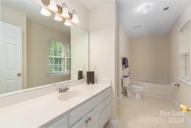 bathroom with vanity, a bathing tub, tile patterned flooring, toilet, and a textured ceiling