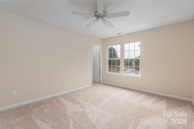 carpeted spare room with ceiling fan and a textured ceiling