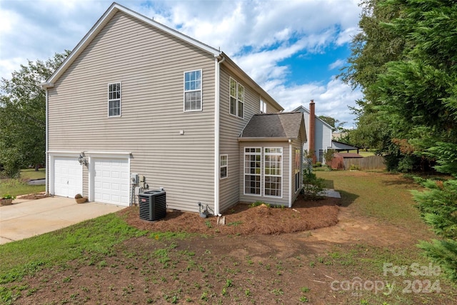 view of property exterior featuring central AC unit and a garage