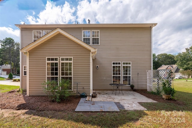 rear view of property with a lawn and a patio