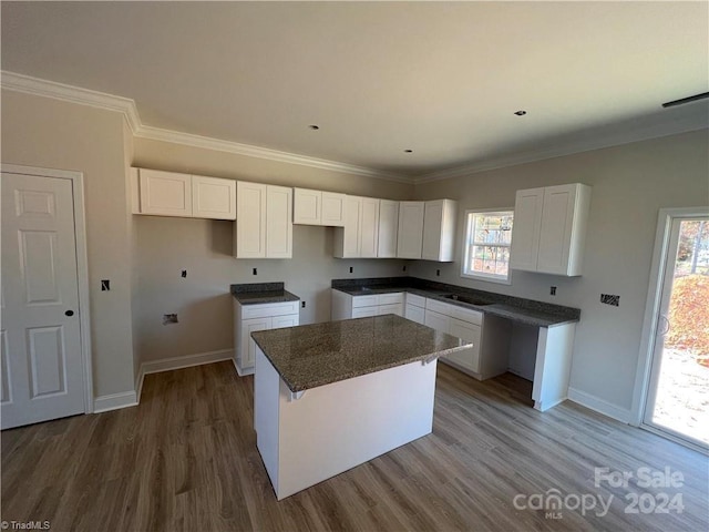 kitchen with white cabinetry, a kitchen island, and a wealth of natural light