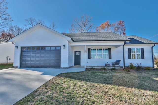 ranch-style home with covered porch, a front yard, and a garage