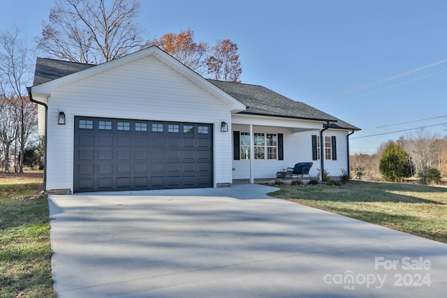 view of front of property with a garage and a front lawn