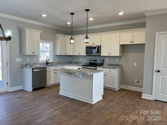 kitchen featuring appliances with stainless steel finishes, white cabinetry, hanging light fixtures, light stone counters, and a kitchen island