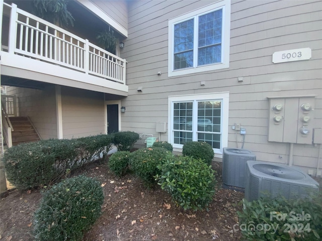 property entrance with a balcony and central AC unit