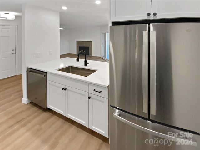 5003 Sharon Rd Unit S, Charlotte, NC 28210 - kitchen featuring appliances with stainless steel finishes, a sink, light wood finished floors, recessed lighting, and white cabinetry