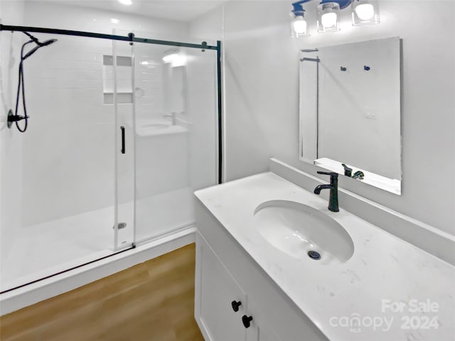 bathroom featuring vanity, hardwood / wood-style flooring, and an enclosed shower