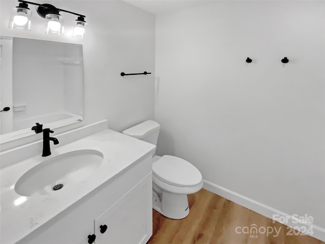 bathroom with hardwood / wood-style floors, vanity, and toilet