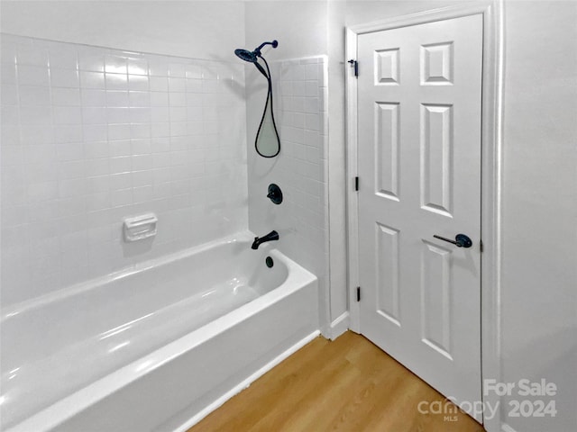 bathroom with hardwood / wood-style floors and shower / tub combination