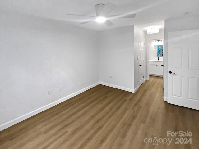 unfurnished room featuring ceiling fan and dark wood-type flooring