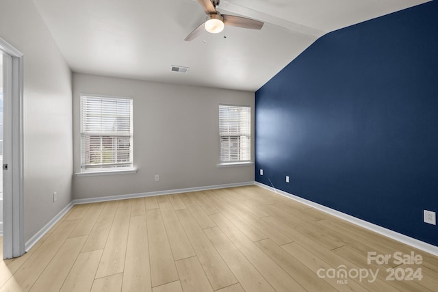 unfurnished room with light wood-type flooring, vaulted ceiling, a wealth of natural light, and ceiling fan