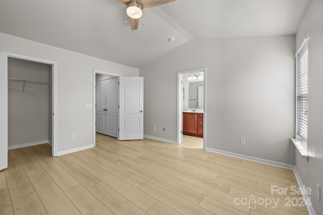 unfurnished bedroom with ceiling fan, light hardwood / wood-style flooring, connected bathroom, a closet, and lofted ceiling