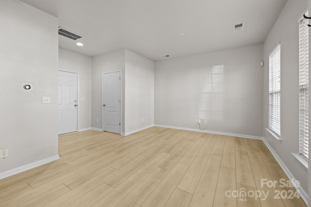 empty room featuring plenty of natural light and light hardwood / wood-style flooring