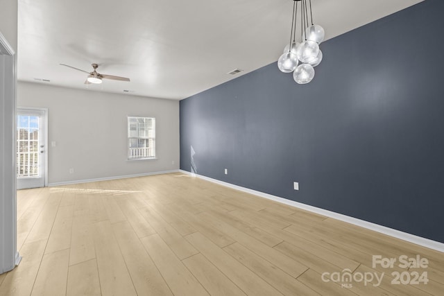 unfurnished room with plenty of natural light, ceiling fan, and light hardwood / wood-style flooring