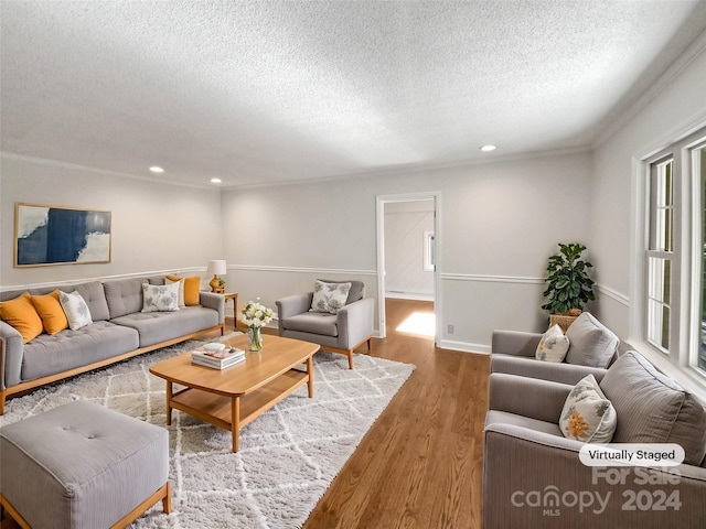 living room with crown molding, a textured ceiling, and hardwood / wood-style flooring