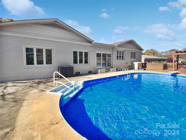 view of pool with a diving board and a patio