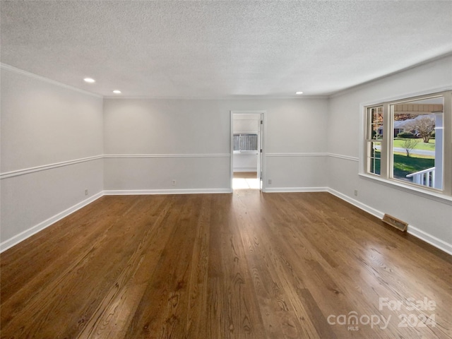 empty room featuring a textured ceiling and hardwood / wood-style flooring