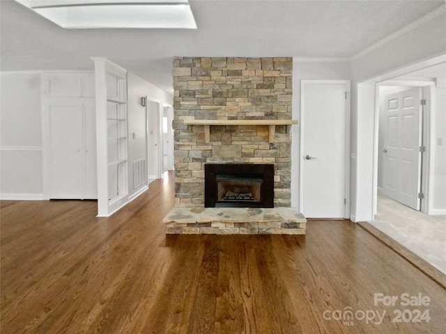 unfurnished living room featuring crown molding, a fireplace, and hardwood / wood-style flooring