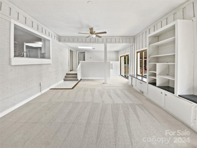 unfurnished living room with light carpet and ceiling fan