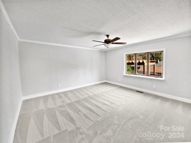 carpeted empty room featuring a textured ceiling, ceiling fan, and ornamental molding