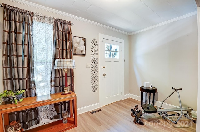 foyer entrance featuring ornamental molding and light wood-type flooring