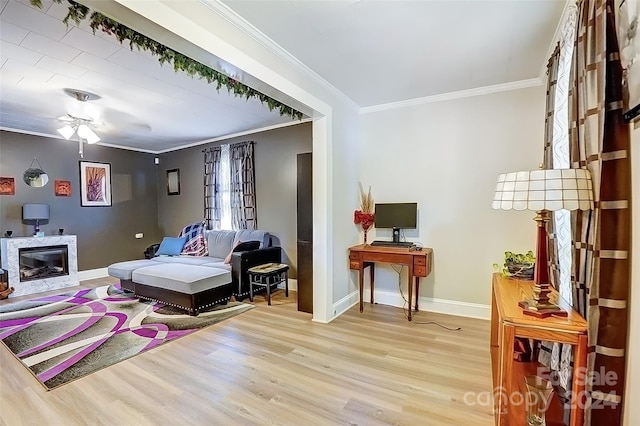 living area featuring ceiling fan, light hardwood / wood-style floors, and ornamental molding