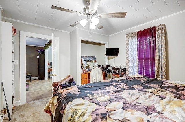 bedroom featuring ceiling fan, crown molding, and light colored carpet