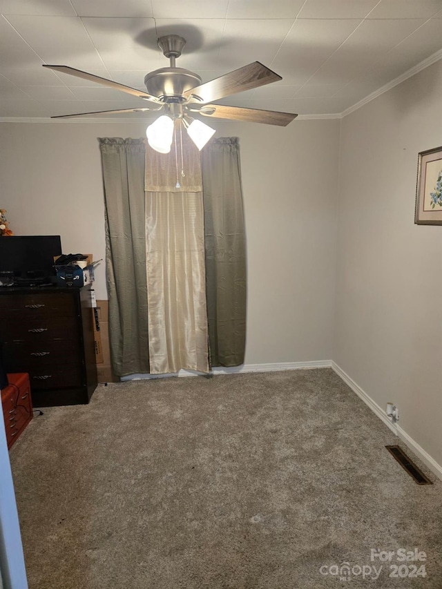 unfurnished bedroom with ceiling fan, ornamental molding, and carpet floors