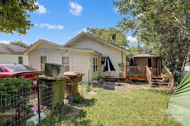 rear view of property with a gazebo and a deck