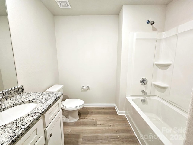 full bathroom with hardwood / wood-style flooring, vanity,  shower combination, and toilet