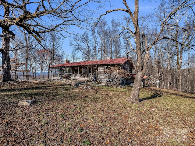 rear view of house featuring covered porch and a lawn