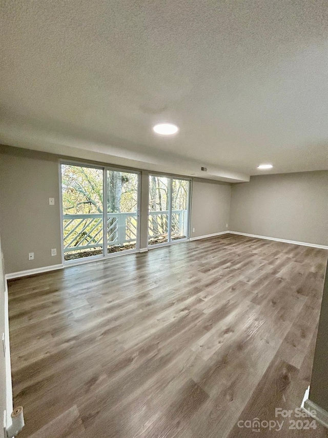 empty room with a textured ceiling and hardwood / wood-style flooring