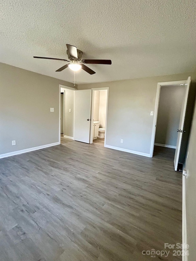 spare room featuring ceiling fan, dark hardwood / wood-style flooring, and a textured ceiling