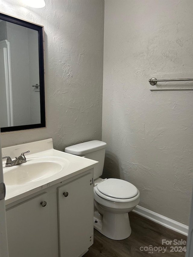 bathroom with vanity, toilet, and wood-type flooring