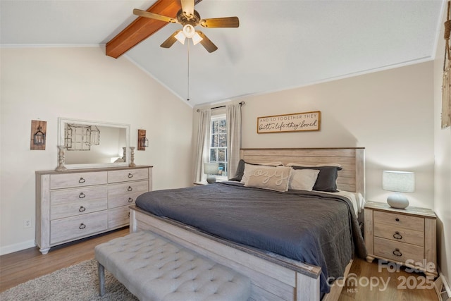 bedroom featuring ceiling fan, vaulted ceiling with beams, and light wood-type flooring