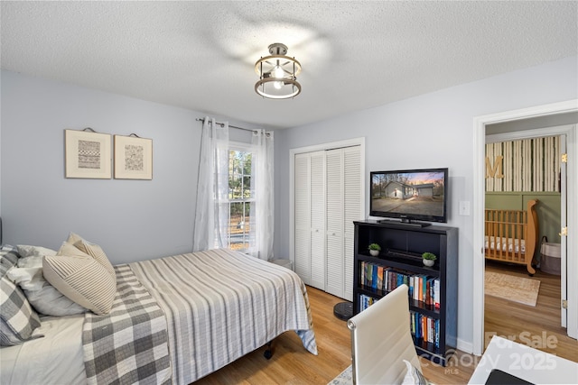 bedroom with a closet, a textured ceiling, and hardwood / wood-style flooring