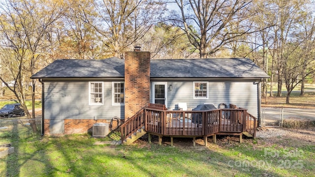 back of house with central AC unit, a deck, and a lawn