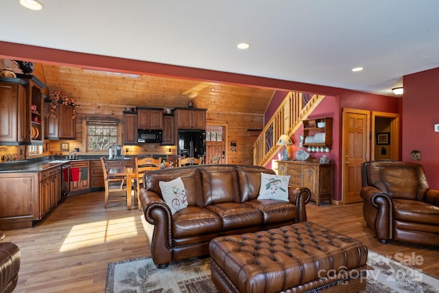 living room featuring light hardwood / wood-style floors and wooden walls