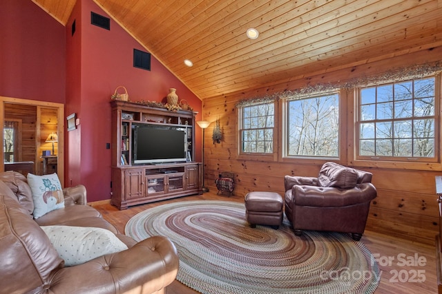 living room with wood walls, wooden ceiling, high vaulted ceiling, and light hardwood / wood-style flooring