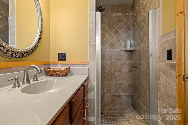 bathroom featuring vanity, tile walls, and tiled shower