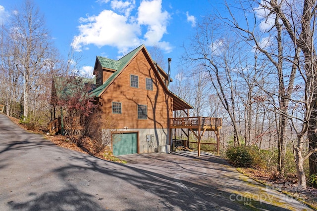 view of home's exterior featuring central AC unit, a garage, and a deck