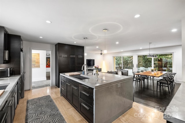 kitchen featuring light hardwood / wood-style floors, sink, and a kitchen island with sink