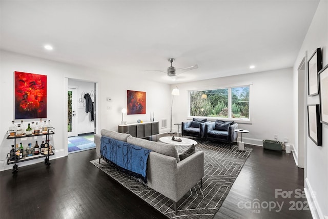 living room featuring dark hardwood / wood-style flooring and ceiling fan