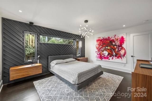 bedroom featuring a chandelier, dark hardwood / wood-style floors, and wooden walls